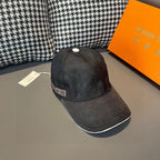 Baseball cap, dark textured fabric, curved brim, side logo patch visible