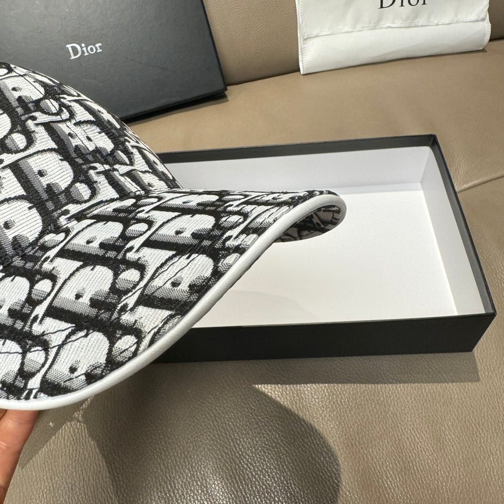 Dior baseball cap brim close-up, black-and-white Dior pattern fabric.
