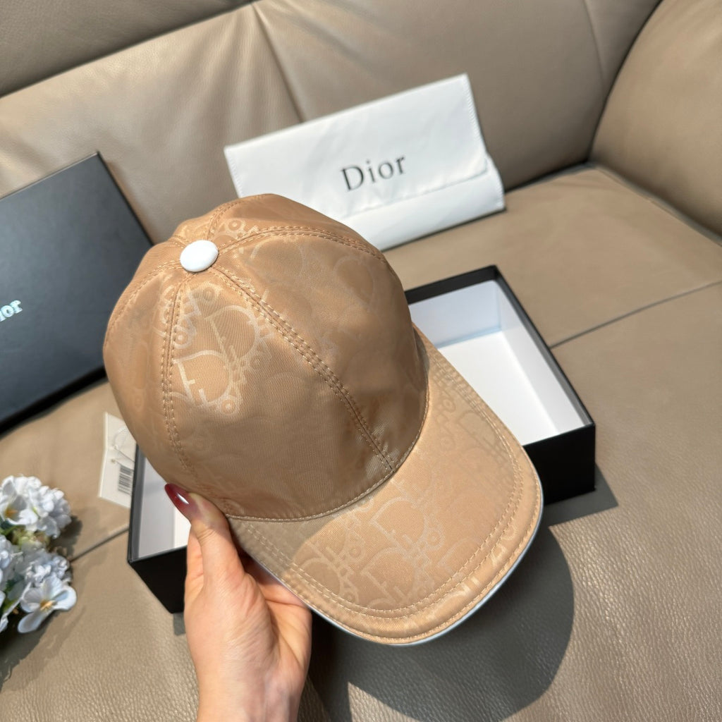 Beige monogram cap shown from side/back, adjustable strap tab and snap button