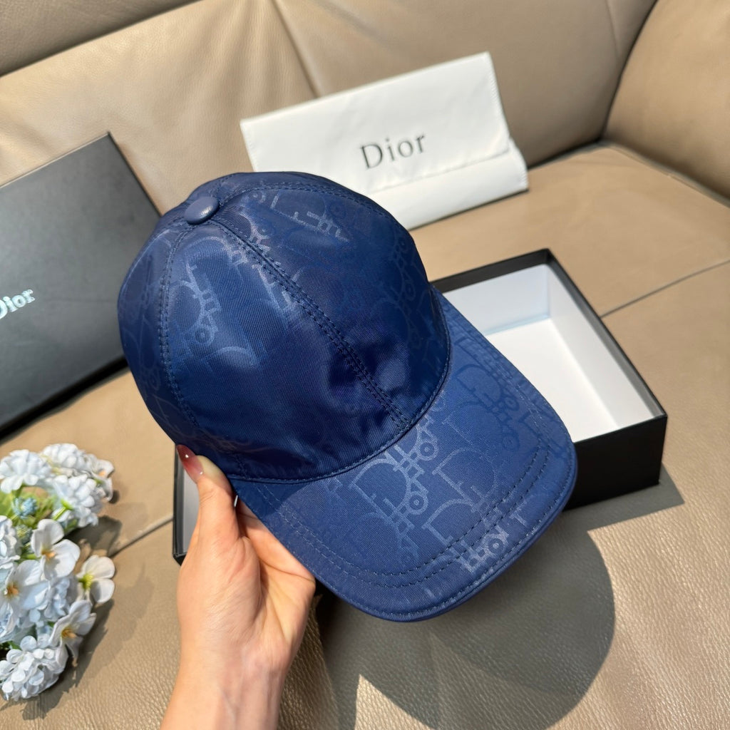 Blue monogram baseball cap shown in hand, curved brim and domed crown