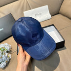 Blue monogram baseball cap shown in hand, curved brim and domed crown