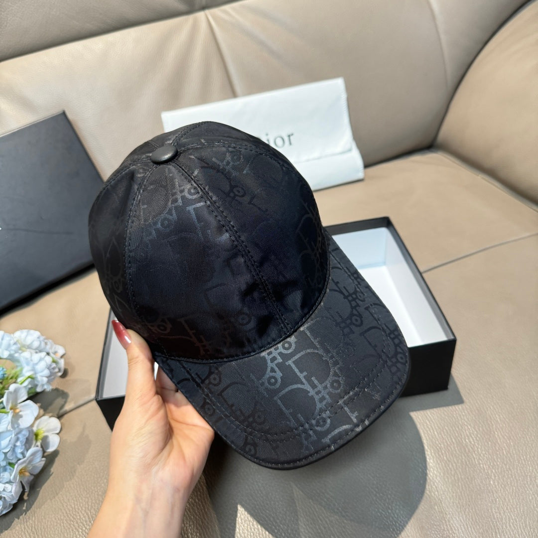 Dior baseball cap in dark monogram-print fabric held by hand, front view with button