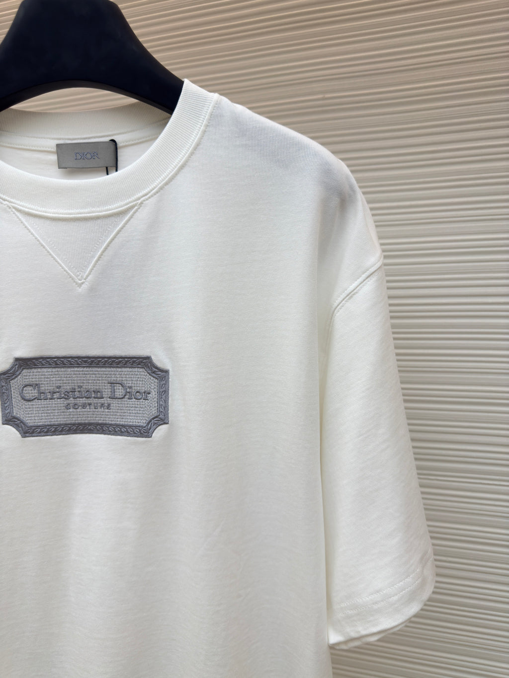White short-sleeve T-shirt logo patch close-up