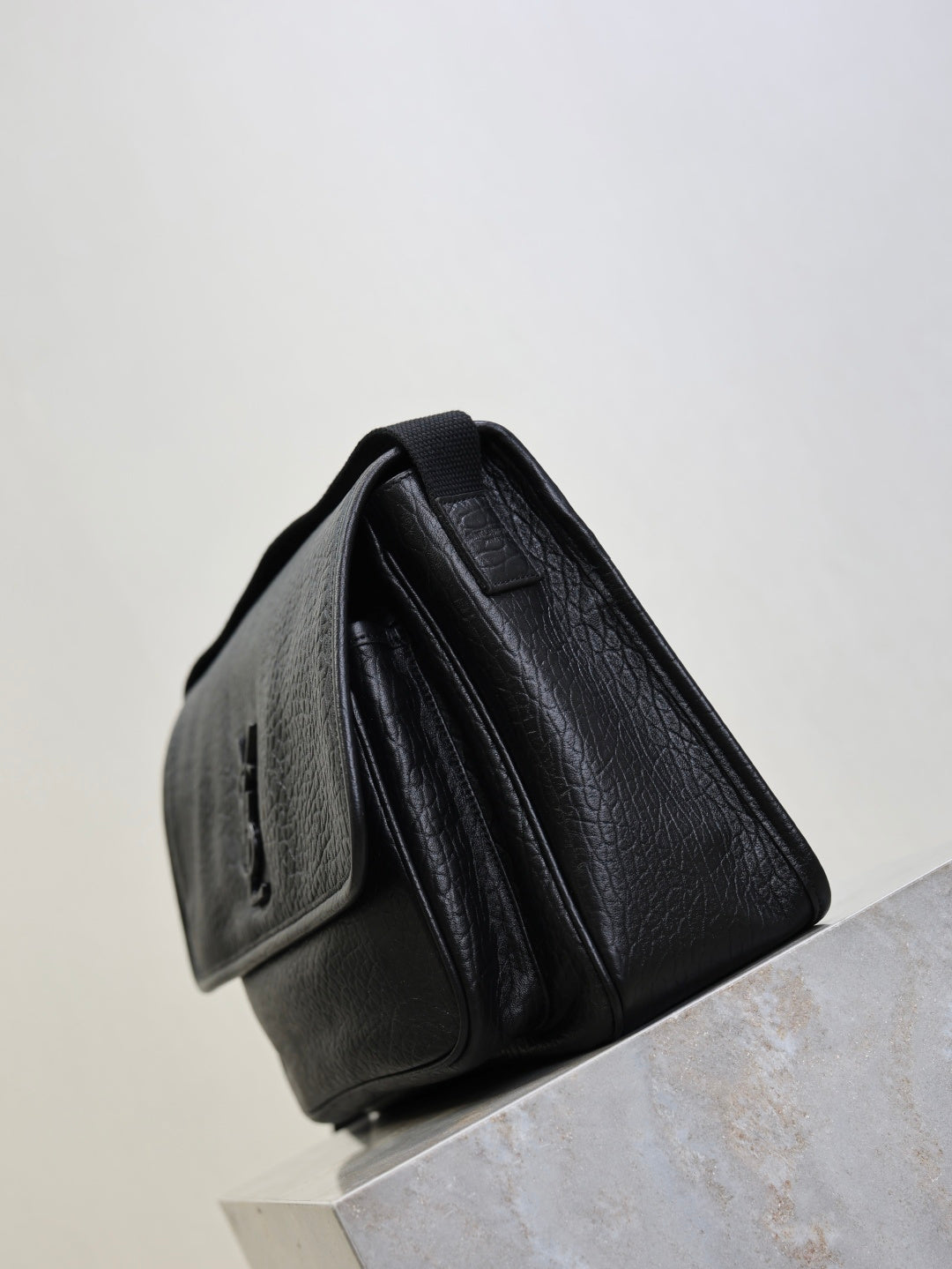 Black textured-leather crossbody bag with back panel and zipper pocket detail