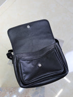 Black textured-leather crossbody bag with front flap and snap button pocket