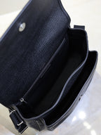 Black textured-leather crossbody bag interior with open top and adjustable strap