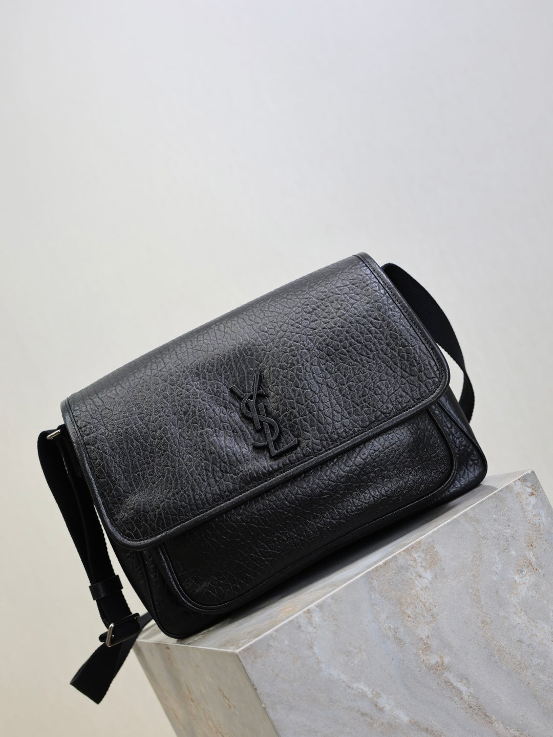 Black textured-leather crossbody bag with front flap and shoulder strap