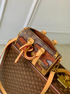Designer monogram handbag with tan crossbody strap and front zipper pocket