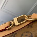 Designer monogram handbag with gold clasp and tan leather trim detail