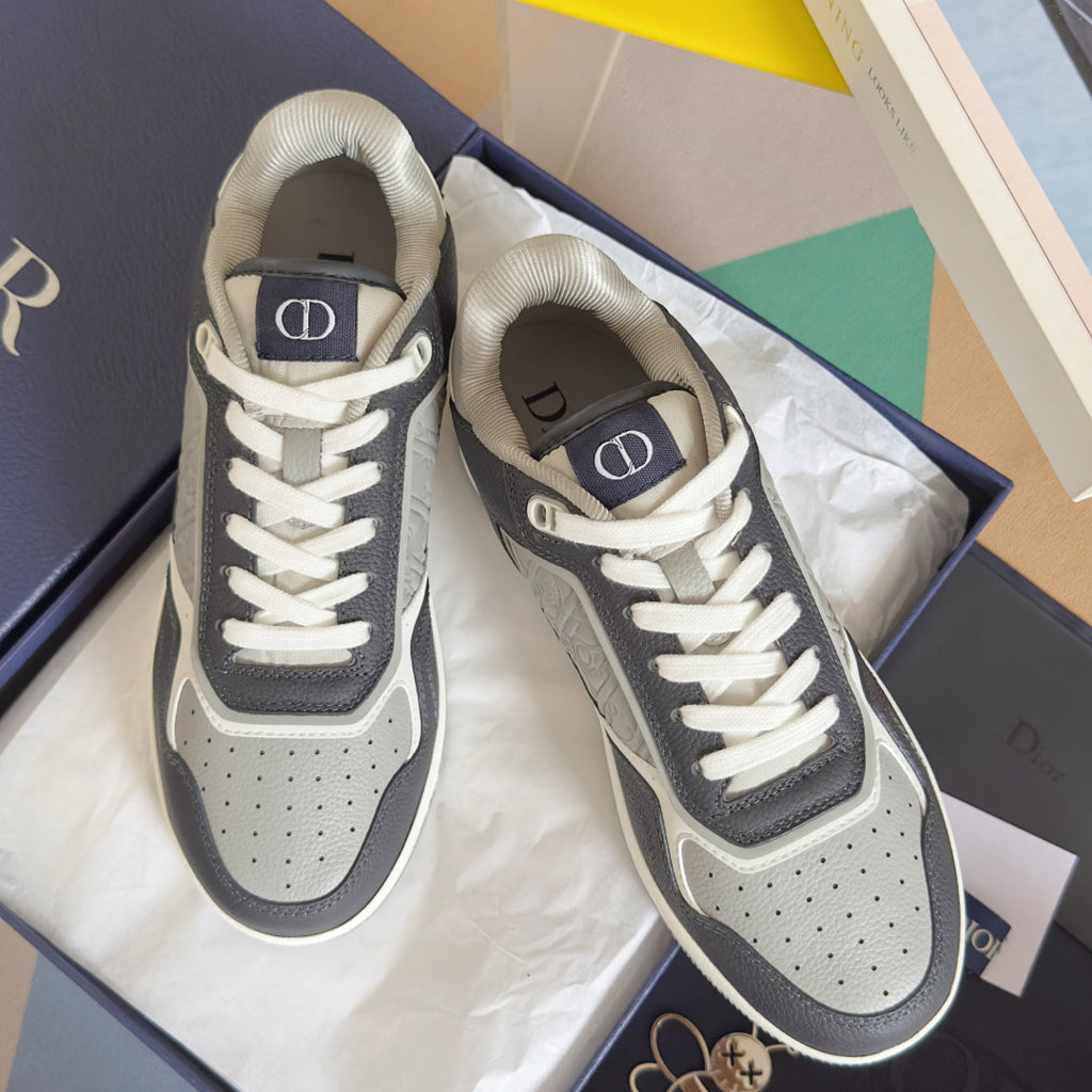 Low-top Dior sneakers in dark blue and white with patterned side inserts, angle view