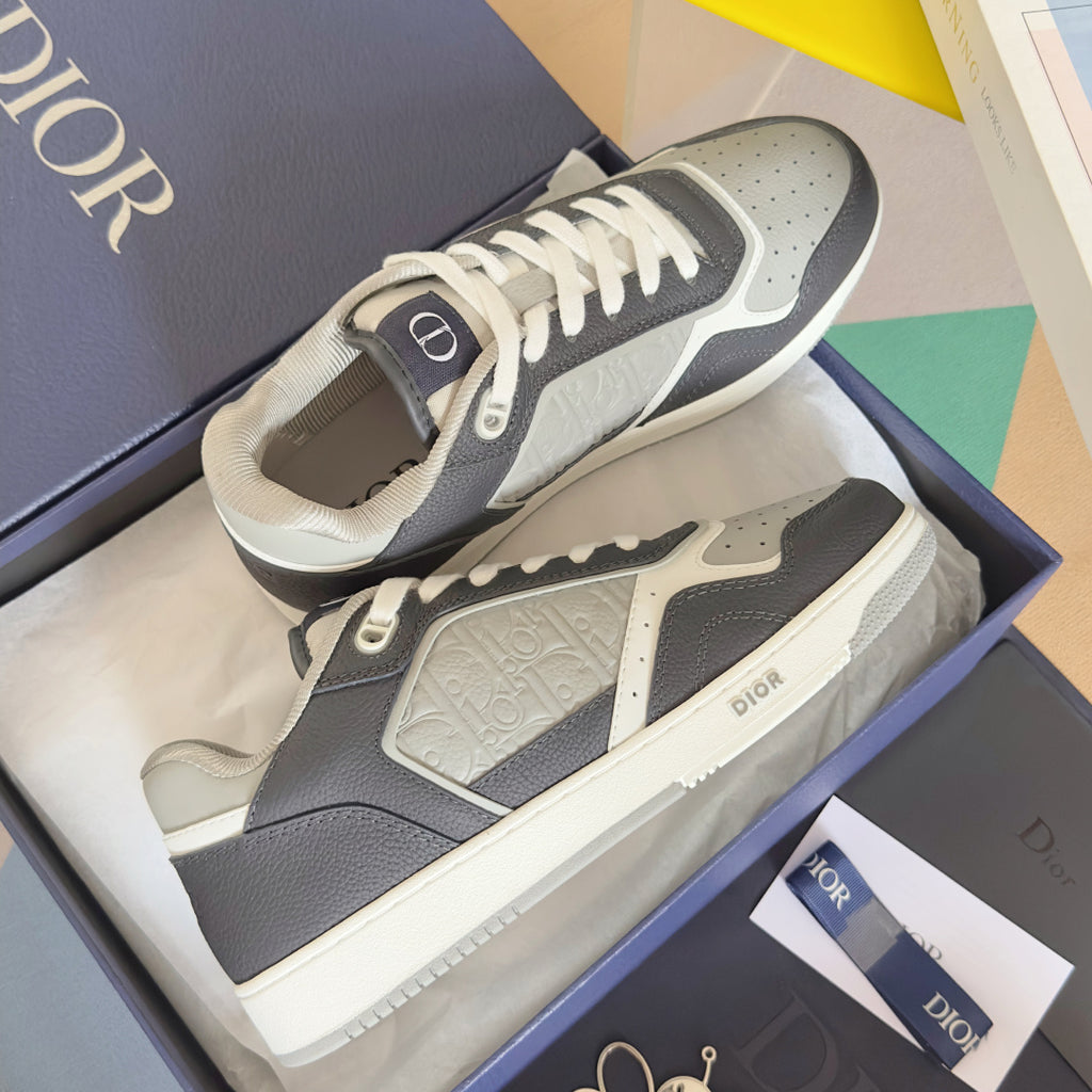 Low-top Dior sneakers laid in a box, dark blue uppers with white toe and laces
