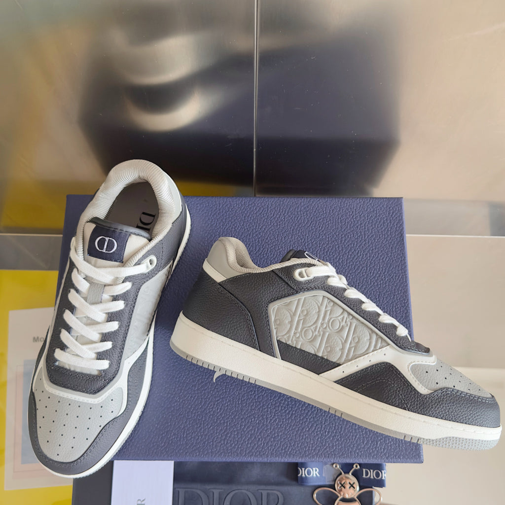 Low-top Dior sneakers showing side panels and white midsole on blue shoebox