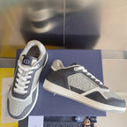 Low-top Dior sneakers showing side panels and white midsole on blue shoebox