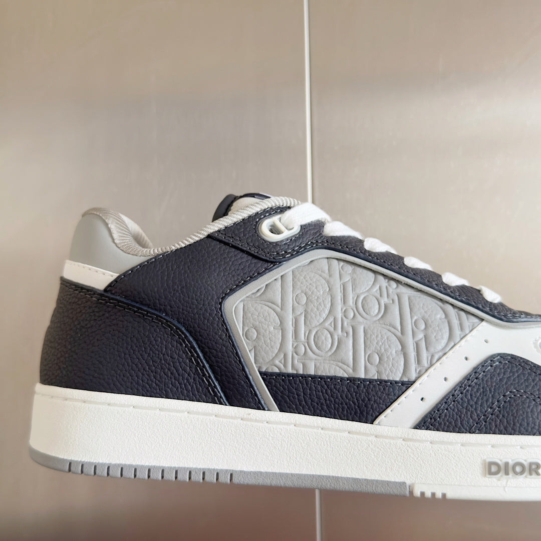 Close-up of low-top Dior sneaker upper, dark blue leather with embossed side panel