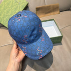 Gucci blue cap front view with button top and GG pattern with red horsebit