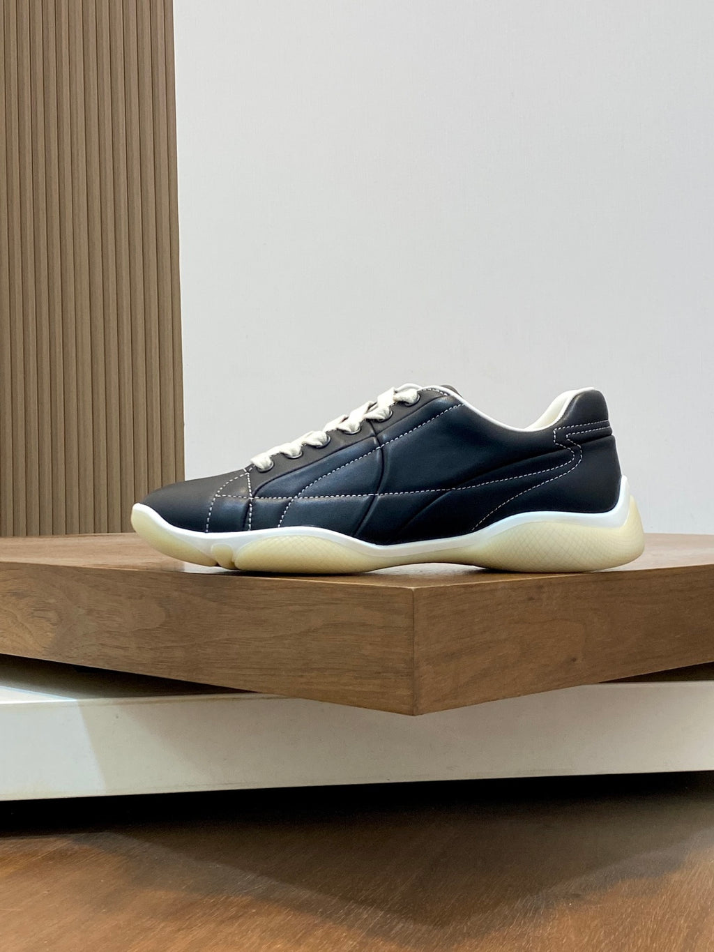 Unisex low-top sneakers, dark navy upper with white laces and cream rubber sole.
