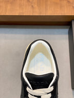 Unisex low-top sneakers with PRADA logo on tongue, black upper and white laces.