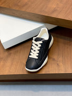 Unisex low-top sneakers on display, black upper with white laces and cream rubber sole.