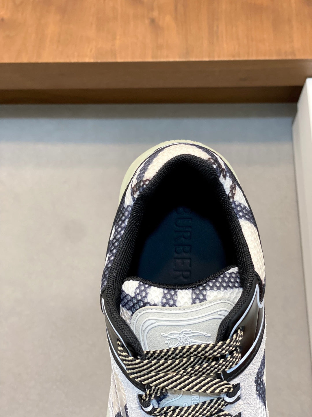 Burberry toe view of patterned sneaker with navy-and-white fabric and padded collar