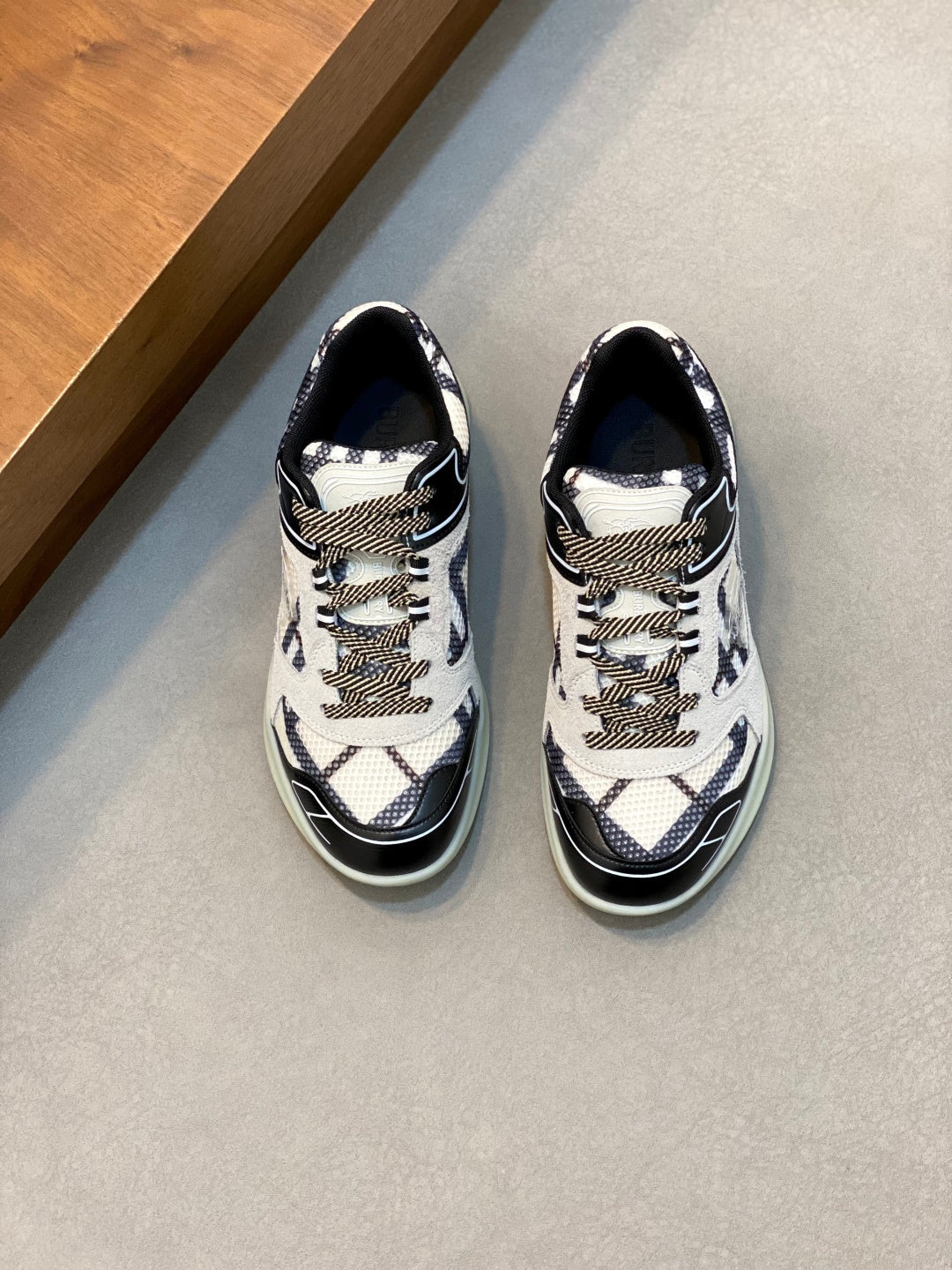 Burberry patterned sneakers with navy and white mesh, black trim, and lace-up front