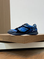 Blue and black athletic sneaker side profile, lace-up with textured upper