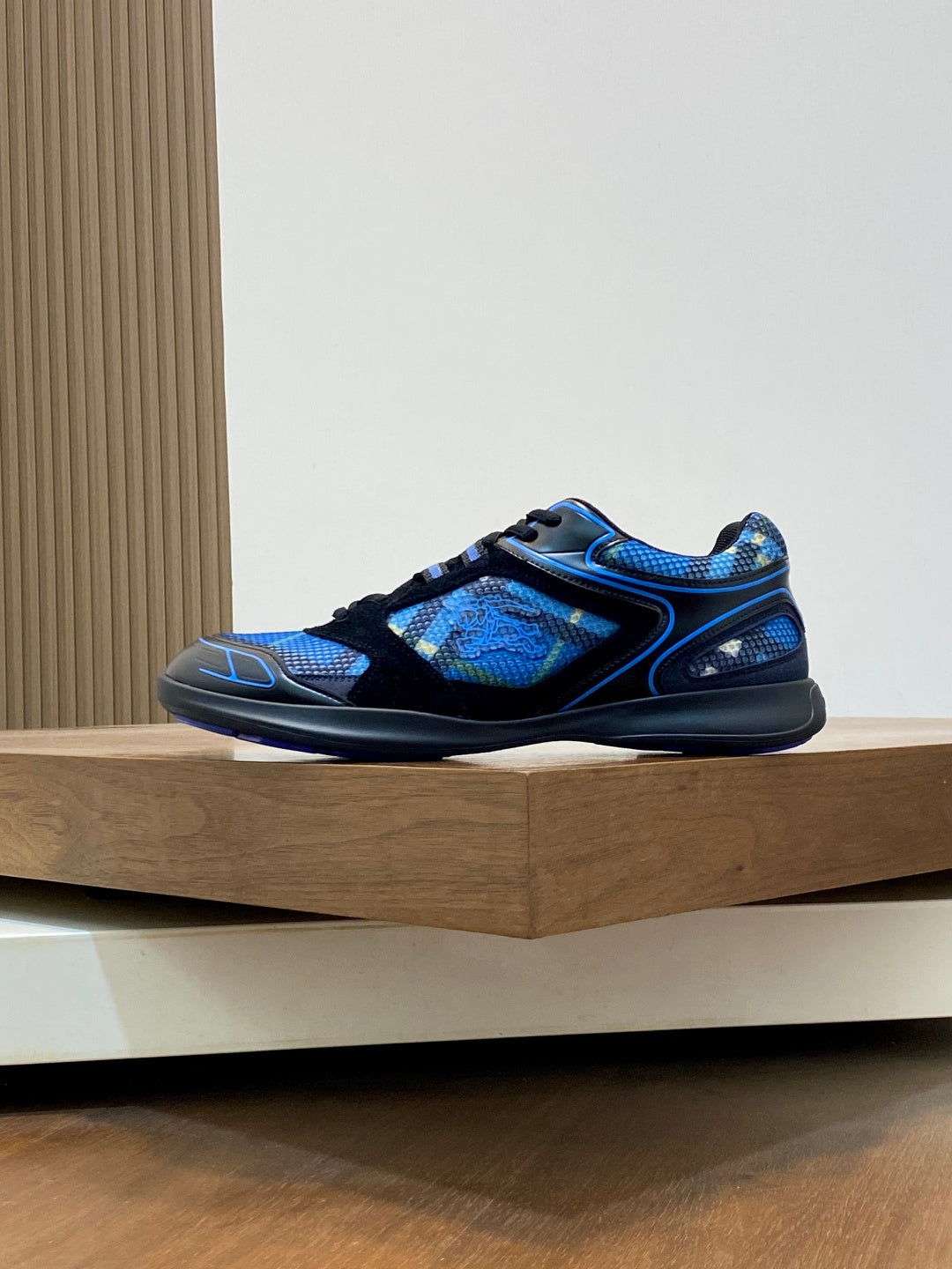 Blue and black athletic sneaker side profile, lace-up with textured upper