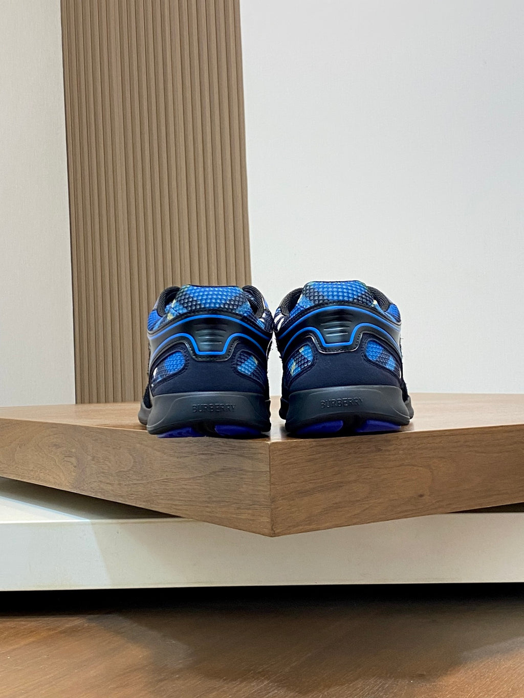 Back view of blue and black athletic sneakers on display shelf