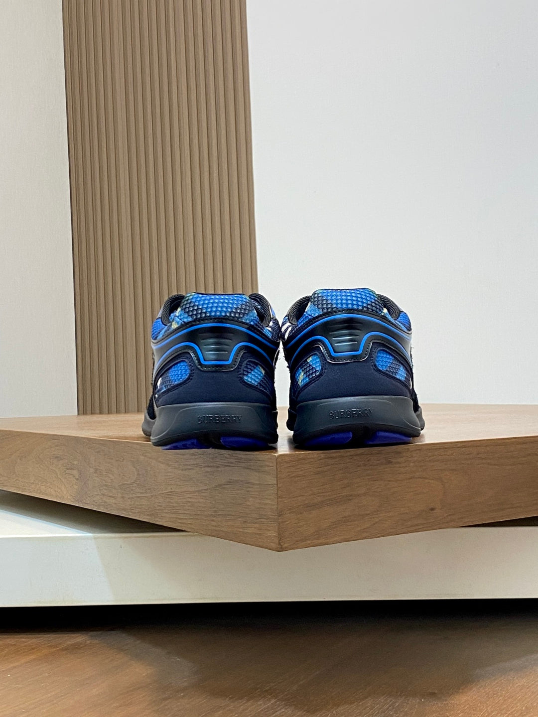 Back view of blue and black athletic sneakers on display shelf