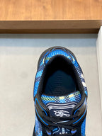 Blue patterned athletic sneaker toe view with black interior lining and laces