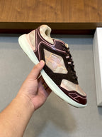 Burberry sneaker held up, lace-up black and beige upper with maroon trim