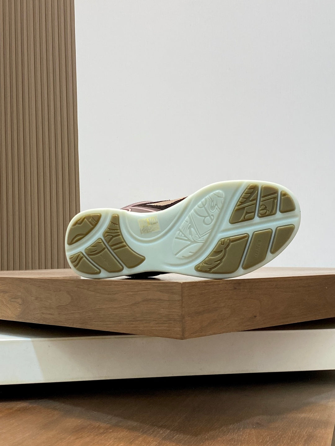 Burberry sneaker outsole view with patterned tread and beige midsole