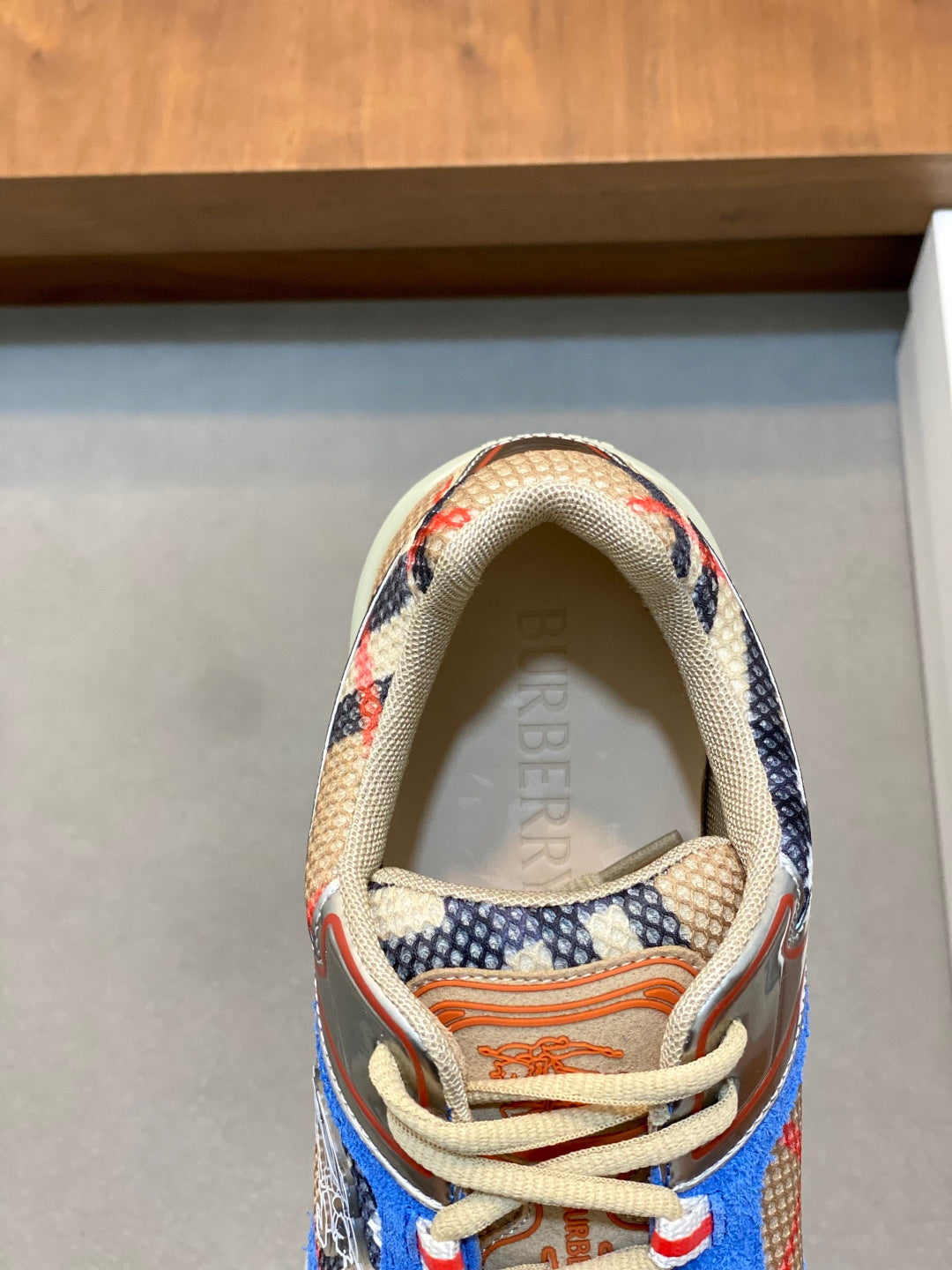 Sneaker interior with Burberry text, beige mesh lining, and multicolor trim