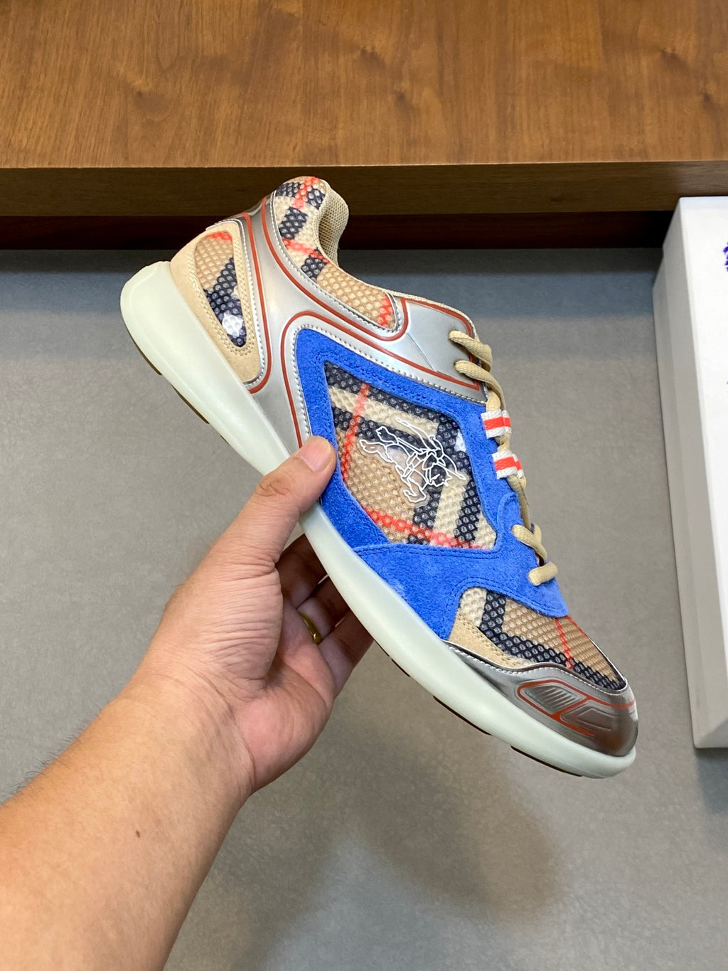 Close-up of blue multicolor lace-up sneaker with patterned upper and cream sole