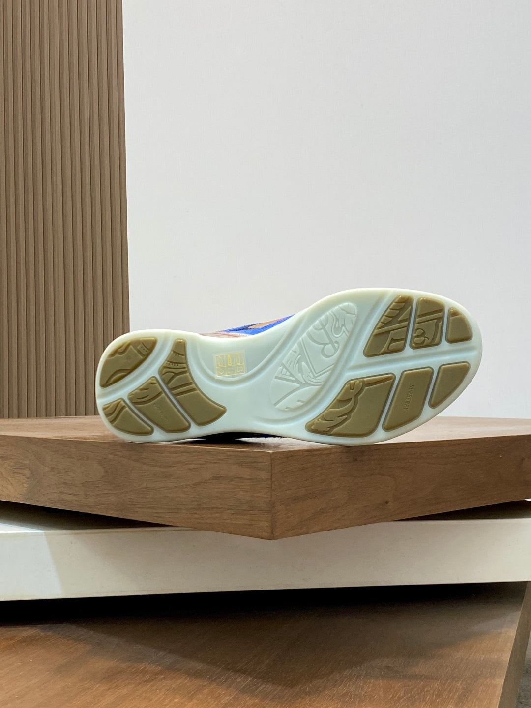Sneaker outsole view with light blue rubber tread and patterned sidewall