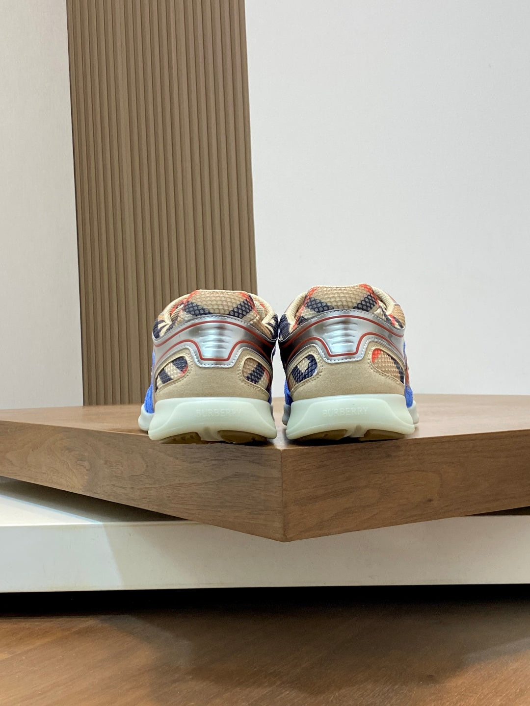 Back view of blue multicolor sneakers on a display platform