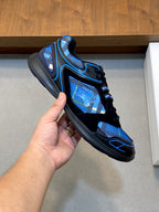 Blue and black athletic sneaker held up, lace-up with padded collar