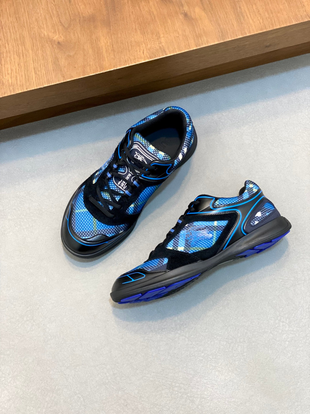 Pair of blue and black athletic sneakers, one front and one side angle
