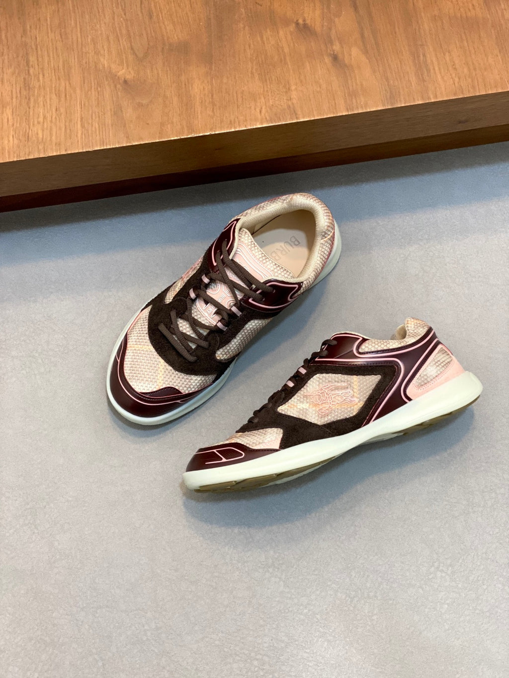 Burberry sneakers pair, lace-up black with maroon accents and light beige upper