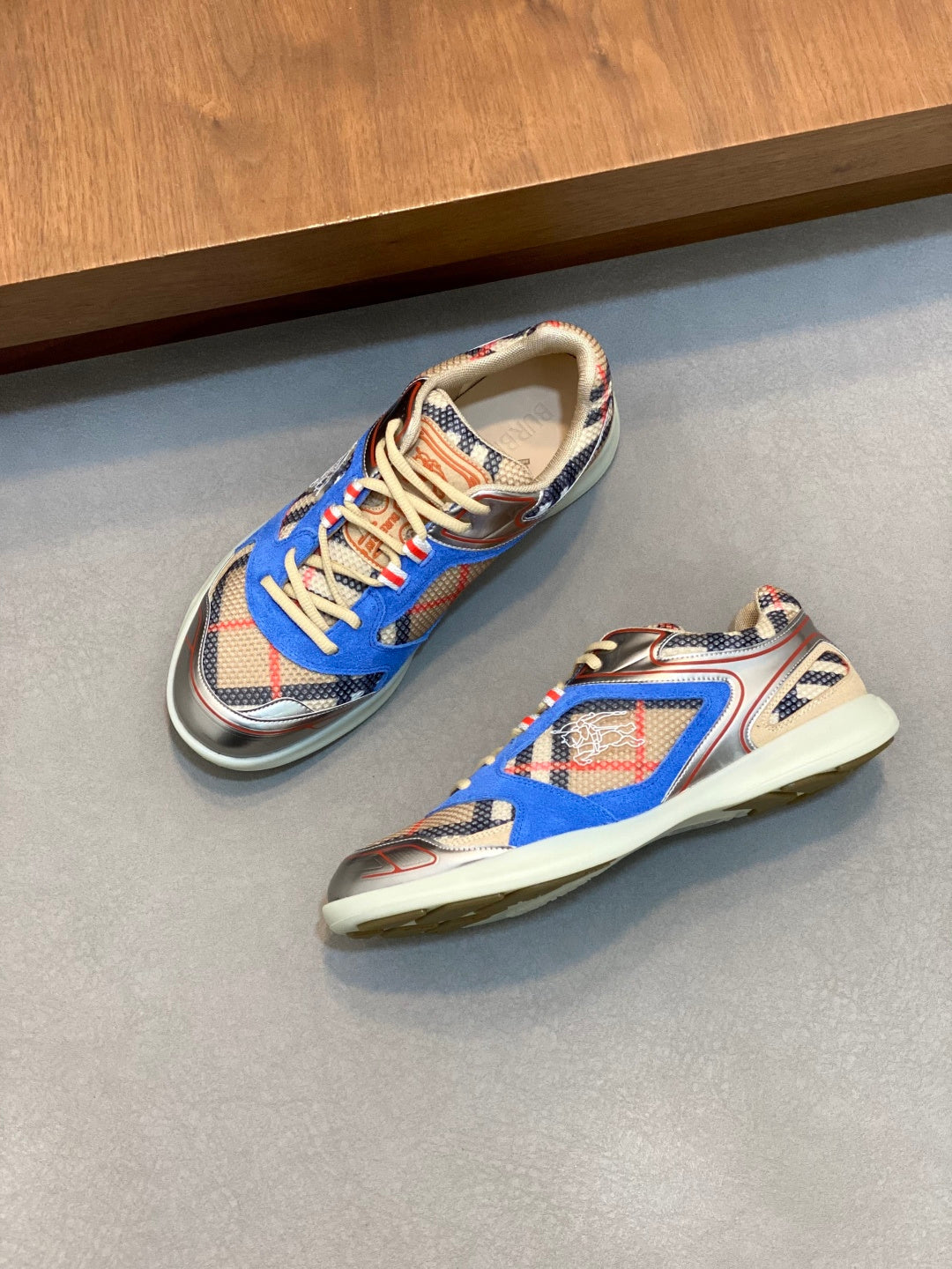 Pair of blue multicolor lace-up sneakers with patterned uppers and cream midsoles