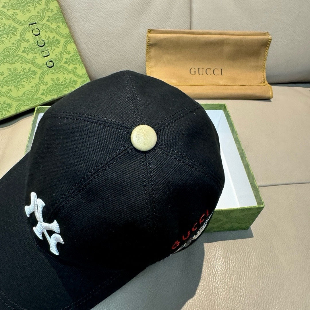 Gucci cap in black with a round gold button at the crown and logo detail