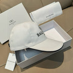 Light-colored baseball cap with curved brim and EB BALENCIAGA logo.
