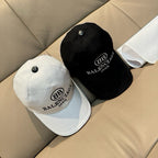White and black baseball caps set with EB logo and BALENCIAGA MODE on front.