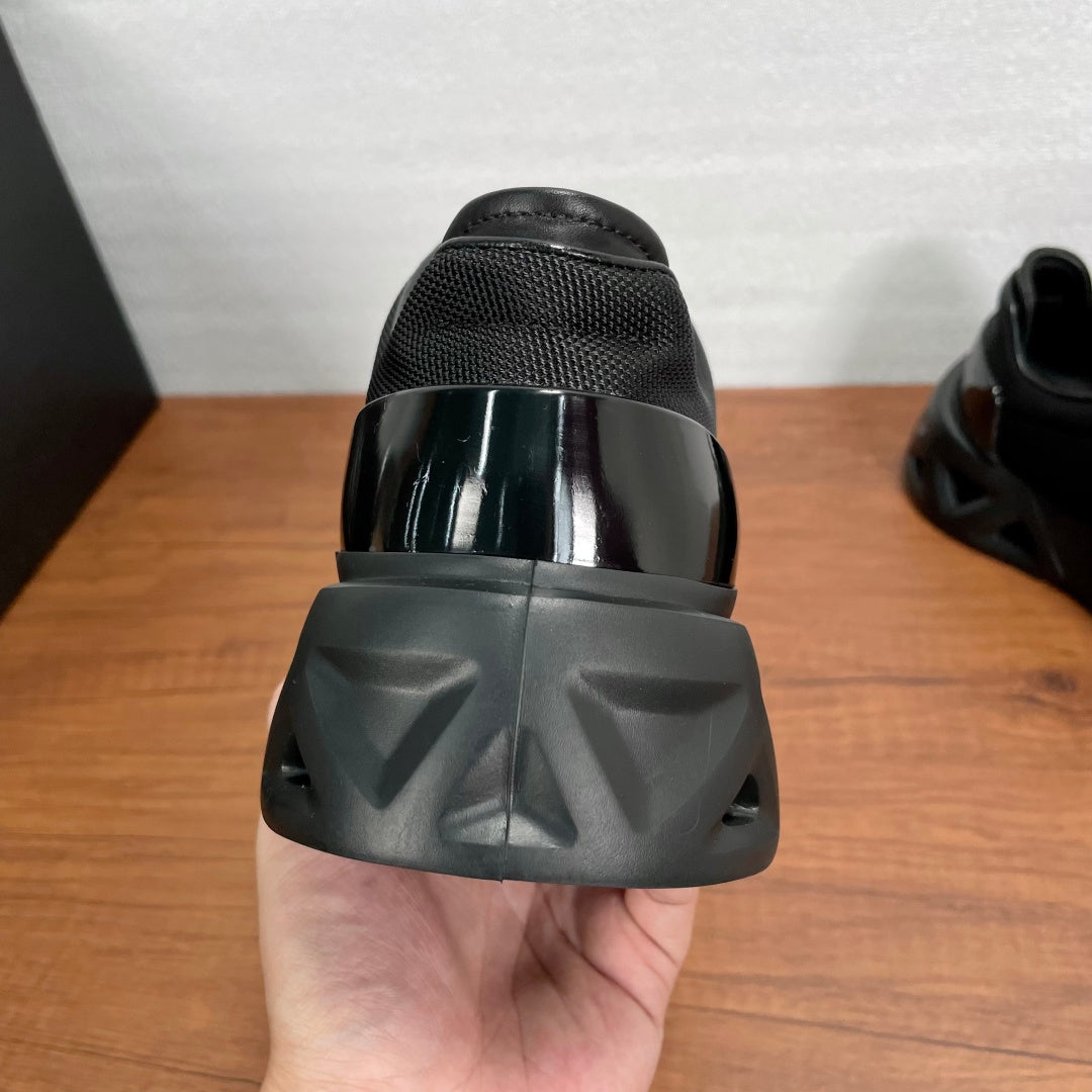 Prada unisex sneaker heel view in black with glossy cap and tread