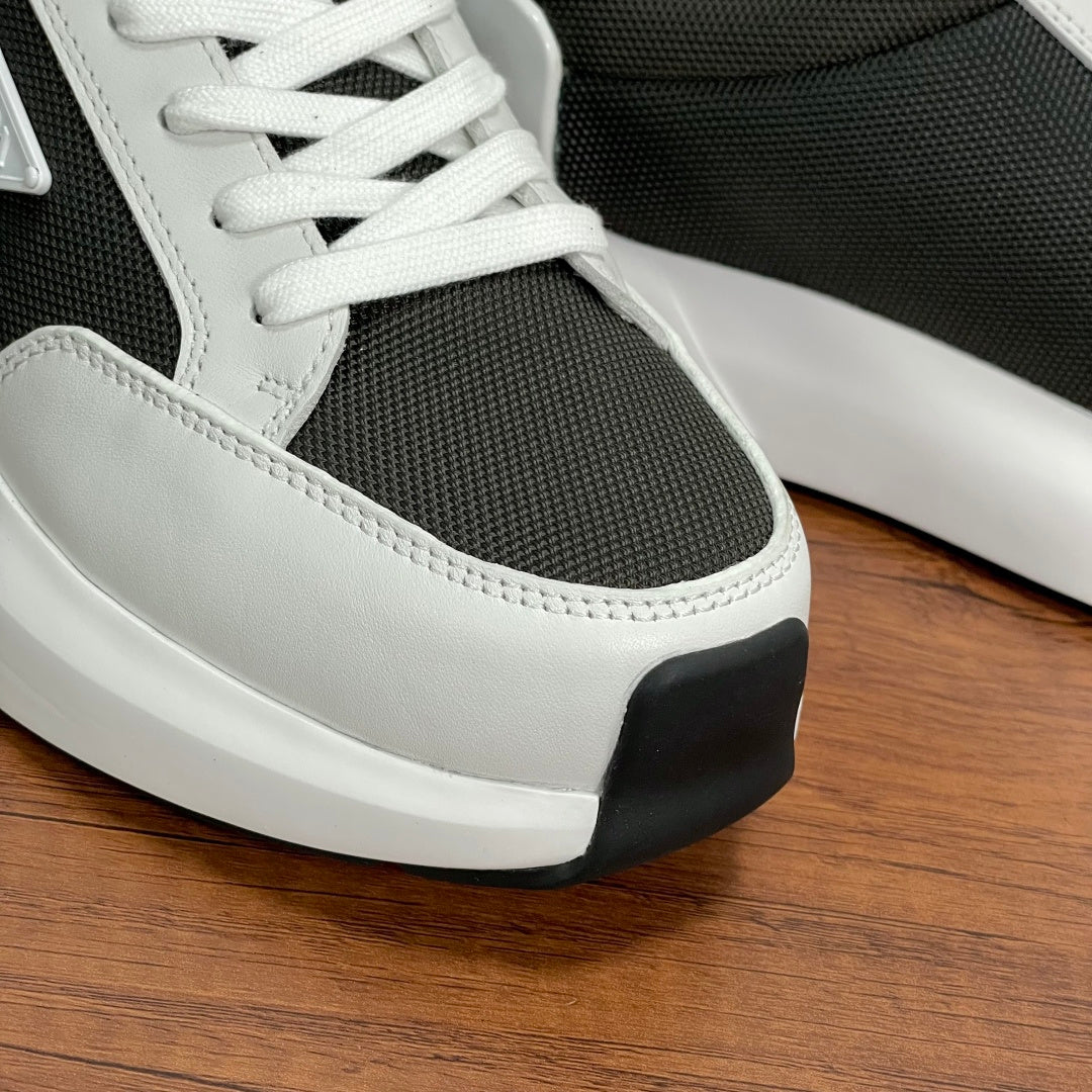 Prada unisex sneaker toe and side close-up, white leather with black rubber trim.