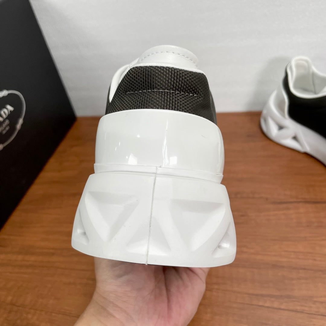 Prada unisex sneakers heel view, white back with black collar and padded sole.
