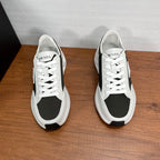 Prada unisex sneakers, white upper with black side panels, lace-up, front pair view.