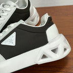 Prada unisex sneaker side close-up, black upper with white overlays and chunky sole.