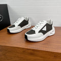 Prada unisex sneakers, black and white lace-up with chunky sole, shown pair view.