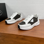 Prada unisex sneakers, black and white lace-up with chunky sole, shown pair view.