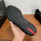 Dark sneaker outsole with textured tread and red logo stripe detail